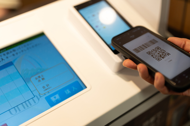カフェのレジでスマートフォンを使ってキャッ